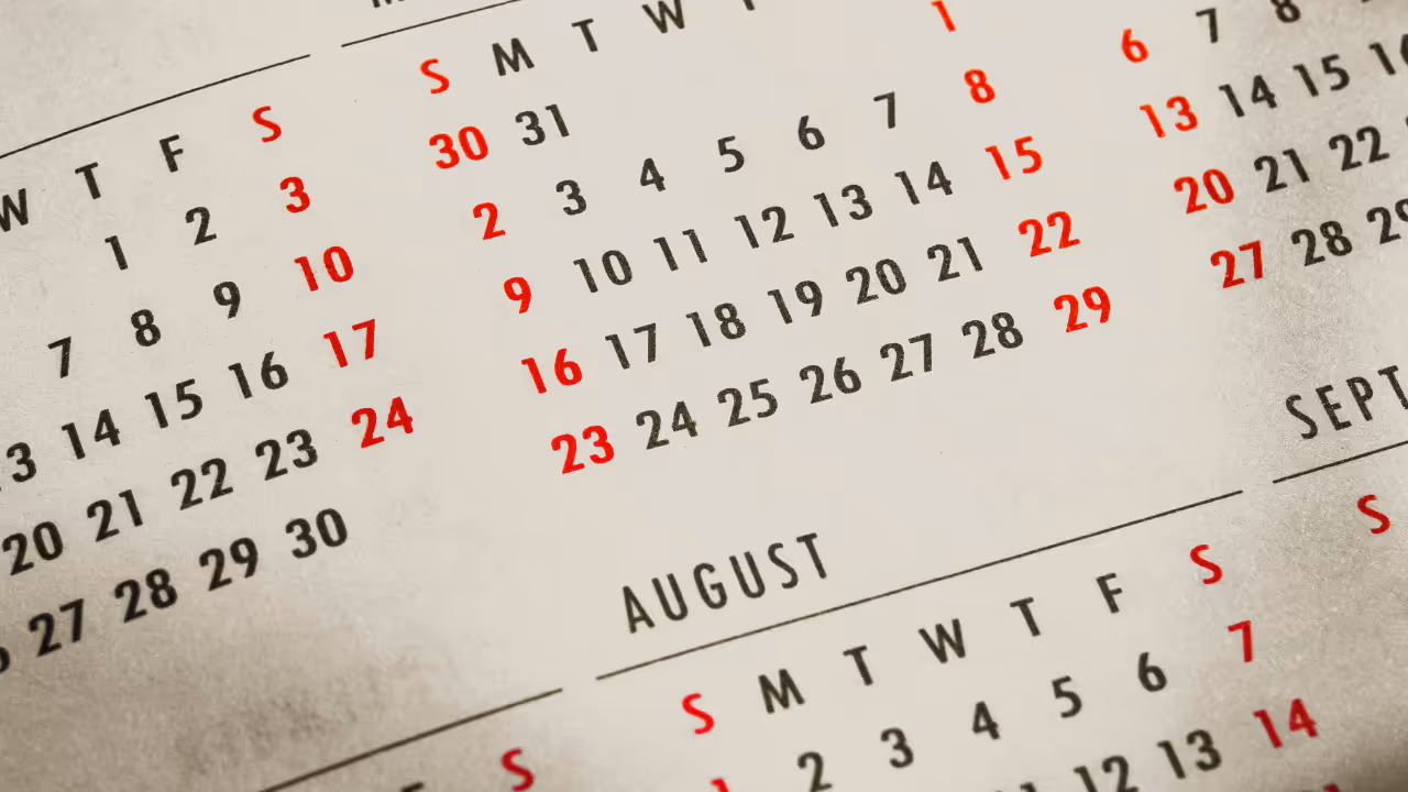 Close-up of a calendar page showing the month of August with Sundays highlighted in red.