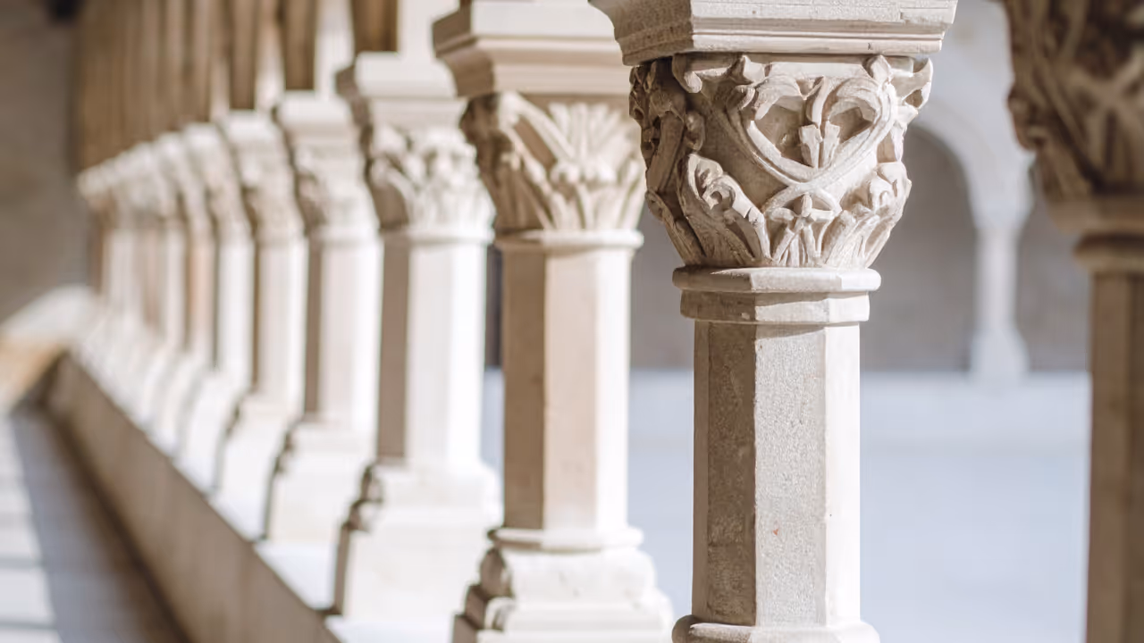 Close-up of intricately carved stone columns in a row with soft natural light.